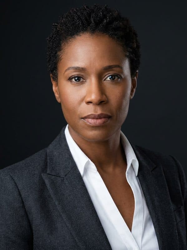 AI-generated example of a Boardroom-style headshot: dark suit against a charcoal studio backdrop